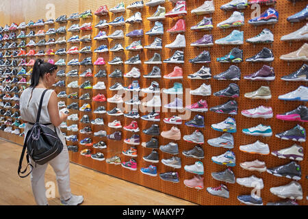 Eine Frau sieht & Thriller Sneakers für Verkauf an den Flight Club am Broadway in Greenwich Village, New York City. Stockfoto