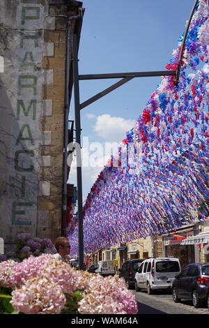 Street Scene mit Blume Festival Girlanden mit einem alten Pharmacie Zeichen auf der Seite eines alten Gebäudes eingerichtet Stockfoto