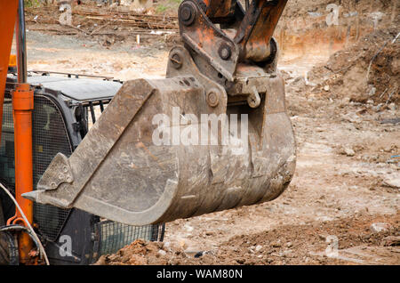 Ende der Schaufel von einem Bagger im Ton und Schmutz auf einer Baustelle in Australien abgedeckt Stockfoto