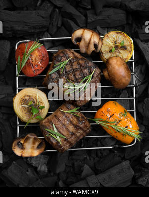 Grid mit vorbereiteten Fleisch Steak und Gemüse vom Grill Stockfoto