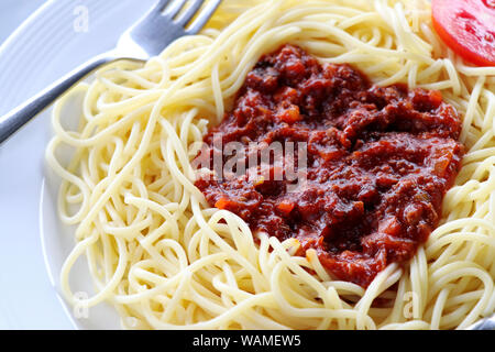 Spaghetti mit Tomatensauce und Hackfleisch. Spaghetti mit Tomatensauce auf einem weißen Teller. Stockfoto