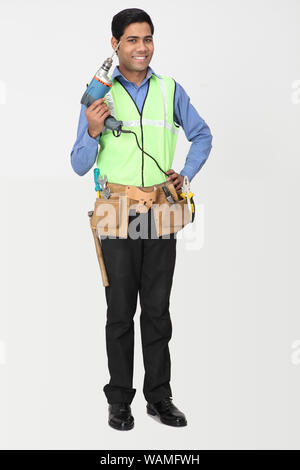 Elektriker mit Bohrer stehen und Lächeln Stockfoto