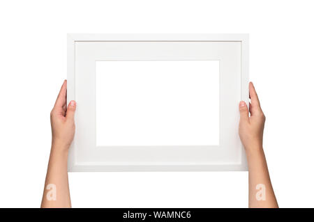 Weißen Rahmen. Frau hängt ein Bild an der Wand. Leeren weißen Rahmen Vorlage. Stockfoto