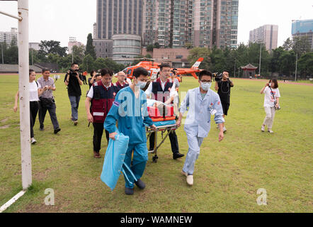 (190821) - CHENGDU, Aug 21, 2019 (Xinhua) - Medizinische Personal Escort einen schwer verletzten Mann per Hubschrauber auf das West China Hospital der Sichuan University, Chengdu transportiert, im Südwesten Chinas Provinz Sichuan, Aug 21., 2019. Acht Menschen starben und 26 blieben fehlen nach heftigen Regenschauern am Dienstag Aba tibetischen autonomen Präfektur Qiang zerschlagen, im Südwesten Chinas Provinz Sichuan, lokale Behörden sagte Mittwoch. Ab Mittag Mittwoch, den Regen - Katastrophen ausgelöst, sechs Menschen verletzt, darunter drei mit schweren Verletzungen, und mehr als 100.000 Menschen müssen evacu werden Stockfoto