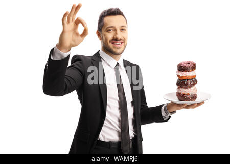 Geschäftsmann mit einer Platte mit Donuts, ein Zeichen für die perfekte mit Hand auf weißem Hintergrund Stockfoto