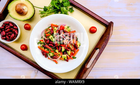 Gesunde vegetarische Avocado und Gartenbohne Sommersalat mit Cherry Tomaten, Zwiebeln und Paprika Stockfoto