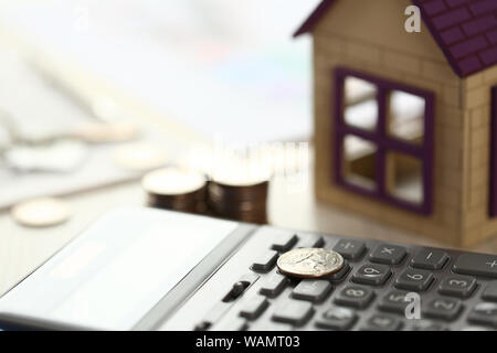 Münze lag auf Rechner, Haus Modell auf Büro Schreibtisch Stockfoto