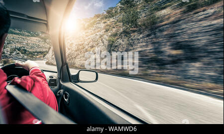 Der Fahrer stürzt entlang der Bergstrasse mit dem Auto. Blick aus dem Auto. Stockfoto