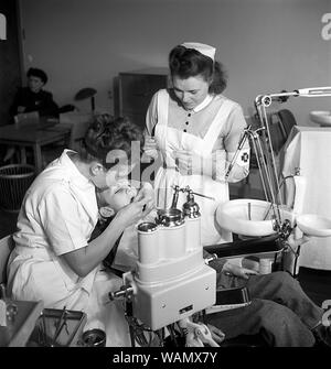 Beim Zahnarzt in den 1940er Jahren. Ein Junge wird von einem Zahnarzt untersucht und behandelt. Eine Krankenschwester unterstützt. Schweden 1948. Kristoffersson ref AH 20-4 Stockfoto