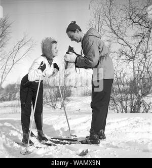 Winter in den 1940er Jahren. Schauspieler Nils Kihlberg, 1915-1965 ist hier mit seiner Frau Ann-Britt. Er nimmt Bilder von ihr auf ihren Winterurlaub. Sie sind beide trugen Winterkleidung und Skier. Die Kamera ist ein von der deutschen Firma Rollei Rolleiflex. Schweden 1943. Kristoffersson Ref D 70-2 Stockfoto