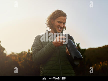 Naturfotograf lächelnd nach der Überprüfung der Fotos auf der Kamera Stockfoto