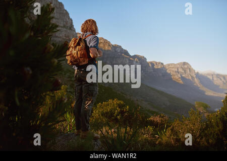 Lächelnden jungen Mann bewundern Sie die Aussicht von Rocky Mountain Stockfoto
