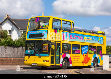 Busters Beach Bus mit offenem Oberdeck, gelber Doppeldecker-Bus, hielt an einer Kreuzung in Westbourne, Bournemouth, Dorset, Großbritannien, an einem warmen, sonnigen Tag im August an Stockfoto