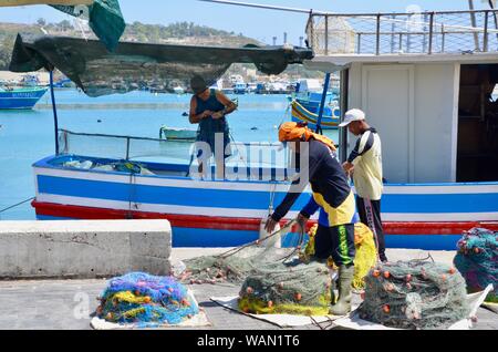 Die Besatzung eines Fischerbootes für Ihren Tag auf marsaxlokk Malta Meer vorbereiten Stockfoto