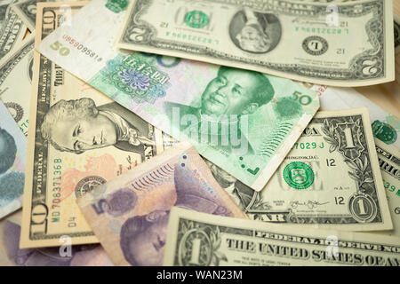 Wählen Sie Fokus von 10 US-Dollar Stapel unter China yuan Banknote. Konzept der Handelskrieg zwischen den USA und China. Stockfoto