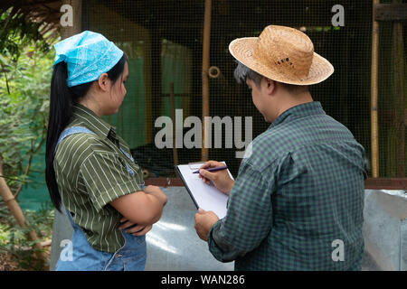 Asiatische Hühnerfarmer ist Lehre und Prüfung der Zuchtbedingungen zu seiner Frau von Legehennen zu reinigen und Qualität Hühnereier Form organischen Fa erhalten. Stockfoto