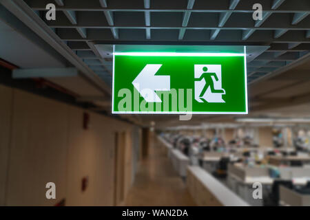 Grüne Notausgang Schild hängen an der Decke im Büro. Stockfoto