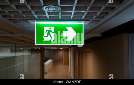 Grüne Notausgang Schild hängen an der Decke im Büro. Stockfoto