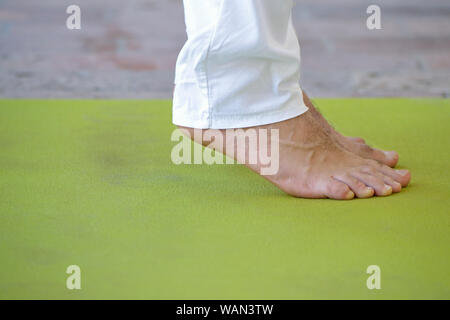 Man Üben Yoga, stehend auf die Zehenspitzen Stockfoto