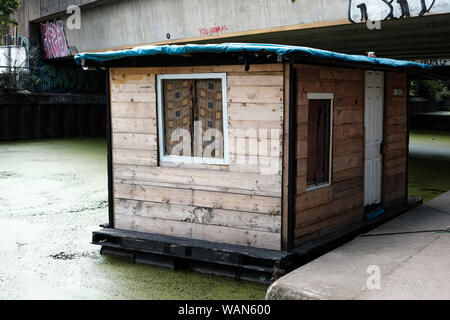 Ungewöhnliche Halle Hausboot canal Boot auf hackney Schnitt, hackney Wick, East London, UK. Kennzeichen zeigt an, dass es mit dem Canal and river Vertrauen registriert ist. Stockfoto