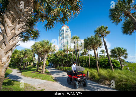 MIAMI - August 19, 2019: in Miami Beach Ocean Rescue Rettungsschwimmer Fahrten zu arbeiten, die mit einem Surfbrett auf seinem ATV. Stockfoto