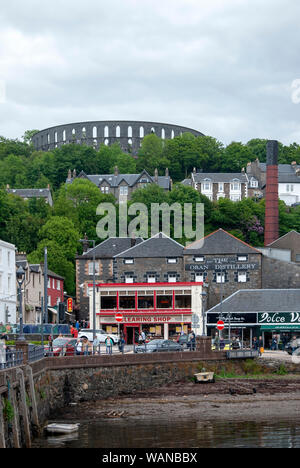 McCaigs Torheit mit Blick auf die Oban Distillery & Waterfront Oban, Schottland Stockfoto