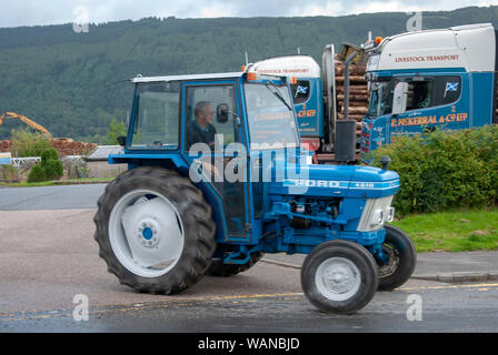 Mann, der 1982 Blau Weiß Ford 4610 Modell Traktor mit Kabine männlichen abseits Treiber Seitenansicht Heiligen Loch Marina 1 Pers Stockfoto