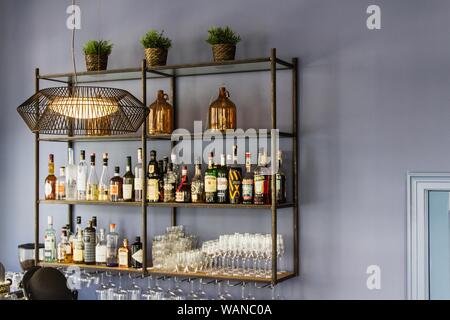 Innenaufnahme einer Bar mit blauen Wänden und verschiedenen Trinkflaschen im Regal Stockfoto