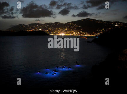 Paddler Kreuzfahrt die Gewässer von Frenchman's Bay in der Dämmerung während einer Nacht Zeit Kajak Ausflug auf St. Thomas, U.S. Virgin Islands. Stockfoto