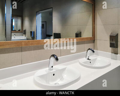 Glänzende Waschbecken und Spiegel in öffentlichen Toiletten. Stockfoto