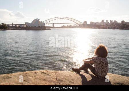 Junger Mann Entspannen am Meer, am Hafen von Sydney, Australien Stockfoto