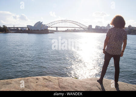 Ein Mann während der Goldenen Stunde, starrte auf das Sydney Opera House Stockfoto