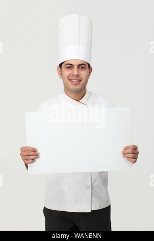 Indischer Koch zeigt ein leeres Plakat Stockfoto