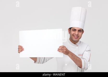 Indischer Koch zeigt ein leeres Plakat Stockfoto