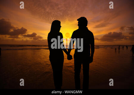 Silhouette von Paar, Hände auf den Strand Stockfoto