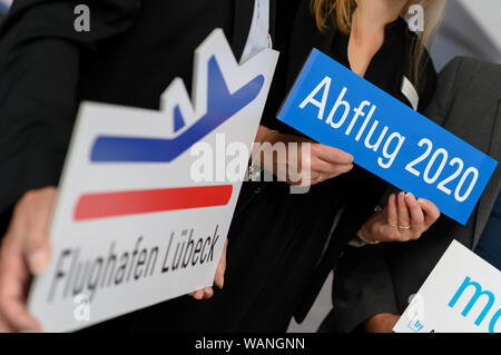 21. August 2019, Schleswig-Holstein, Lübeck: der Beschilderung zum Flughafen Lübeck und Abreise 2020 wird im Gebäude des Flughafens auf einer Pressekonferenz zur Wiedereröffnung der Flughafen für Urlaub und Charter Verkehr von 2020 angezeigt werden. Im kommenden Jahr zwei Charterflüge der Flensburger tour operator Neubauer Touristik sind der Anfang zu machen. Vier Jahre nach dem letzten Flug der Ungarische Billigfluggesellschaft Wizz Air, Passagier Flugzeuge starten und landen am Flughafen Lübeck wieder ab 2020. Foto: Rainer Jensen/dpa Stockfoto