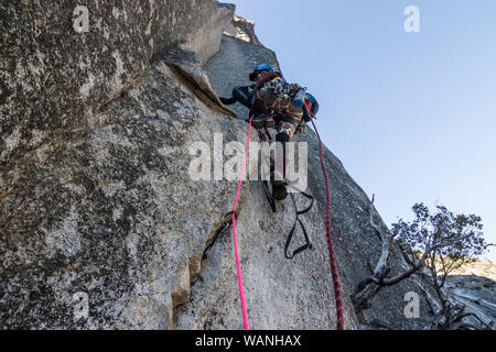 Eine junge Frau Kletterer legt auf ihrer ersten Klettern führen. Stockfoto