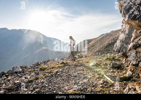 Eine junge Frau Trail Runner nimmt einen Bruch hoch oben auf dem Arapaho Pass Stockfoto