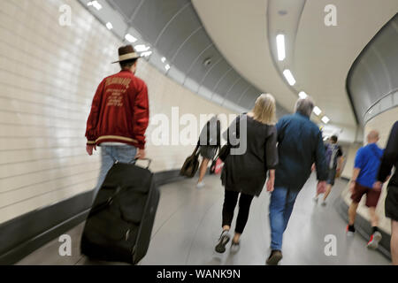Ansicht der Rückseite des Menschen reisenden Passagiere zu Fuß in das Versandverfahren in einen unterirdischen Tunnel in der Stadt London England UK KATHY DEWITT Stockfoto