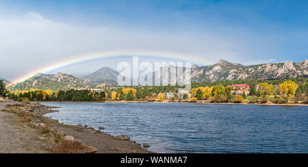 Ein Regenbogen Formulare über See Estes, das Stanley Hotel, See Estes 9-Loch Golfplatz und der Innenstadt von Estes Park im Herbst Farben Farbe an der Küste in hinzufügen Stockfoto