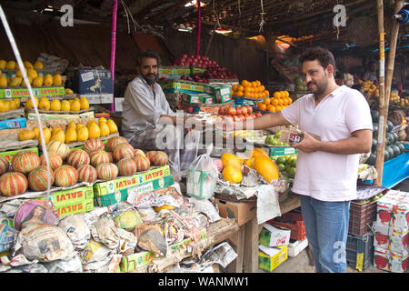 Kunde zahlt Geld an einen Ladenbesitzer an einem Marktstand, Gurgaon, Haryana, Indien Stockfoto
