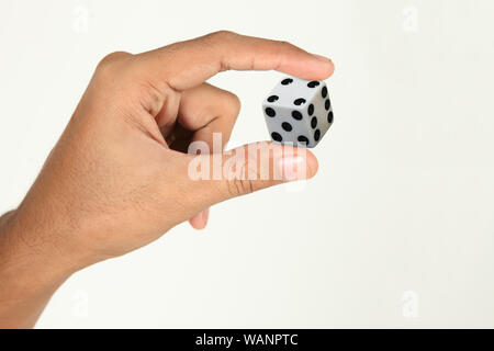 Menschliche Hand hält einen Würfel Stockfoto