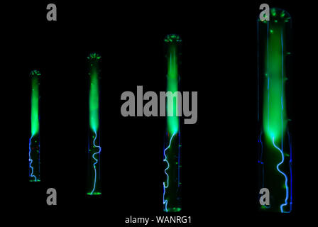 Blitz- und Grün leuchtende elektrische Entladungen in Flaschen mit Inertgas auf schwarzem Hintergrund Stockfoto