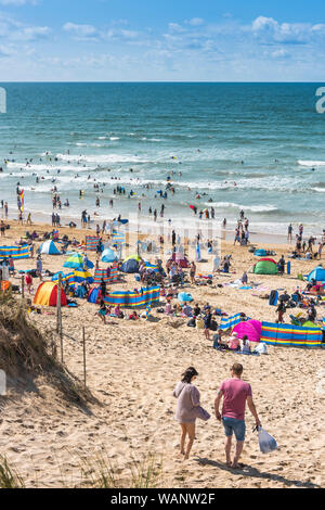 Urlauber auf einem sonnigen Fistral Beach in Newquay in Cornwall. Stockfoto