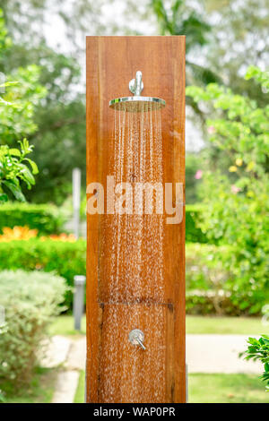 Dusche im Freien Kopf auf der Holzplatte pole Design zum Duschen Körper vor dem Sprung in das Resort Pool. Stockfoto