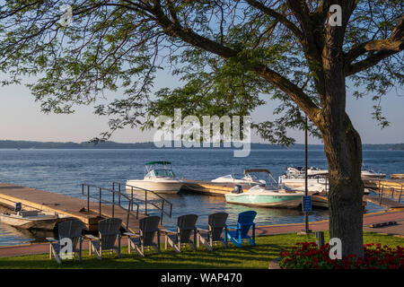 Reihe von Adirondack-Stühlen mit Blick auf eine Marina- und Meereslandschaft in der Stadt Clayton, Jefferson County, NY, USA Stockfoto