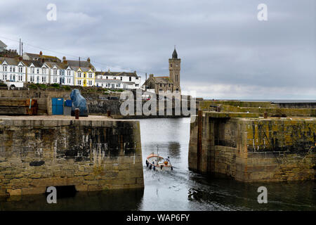 Fischer verlassen Stein Pier Hafen von Porthleven mit Bickford Smith Institut Porthleven Stadtrat Gebäude auf dem Atlantischen Ozean Cornwall Engla Stockfoto