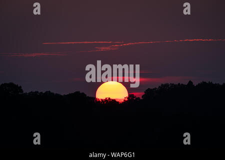 Die Sonne geht hinter einem Hügel in dieser Szene aus ländlichen Appalachia. Stockfoto