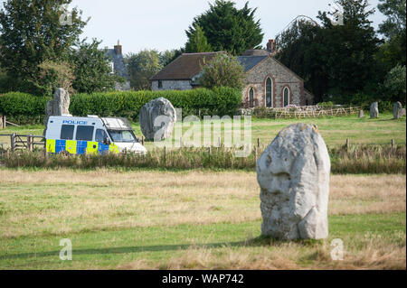 Avebury, Wiltshire, UK. 21. August 2019. Einen Polizeiwagen geht durch das Weltkulturerbe von Avebury, der Heimat der berühmten Henge und alten Steinkreis. Berichte von weit rechts zeremoniellen Aktivität auf Websites wie Avebury und Wayland Smithy, eine neolithische Grabkammer in Oxfordshire, in nationalen Zeitungen vor kurzem veröffentlicht worden. Als Konsequenz, Sicherheit wurde durch den National Trust, die der Jungsteinzeit managt ausgeweitet worden. Quelle: Lee Thomas/Alamy leben Nachrichten Stockfoto