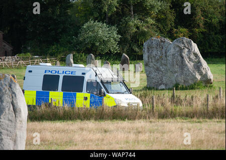 Avebury, Wiltshire, UK. 21. August 2019. Einen Polizeiwagen geht durch das Weltkulturerbe von Avebury, der Heimat der berühmten Henge und alten Steinkreis. Berichte von weit rechts zeremoniellen Aktivität auf Websites wie Avebury und Wayland Smithy, eine neolithische Grabkammer in Oxfordshire, in nationalen Zeitungen vor kurzem veröffentlicht worden. Als Konsequenz, Sicherheit wurde durch den National Trust, die der Jungsteinzeit managt ausgeweitet worden. Quelle: Lee Thomas/Alamy leben Nachrichten Stockfoto